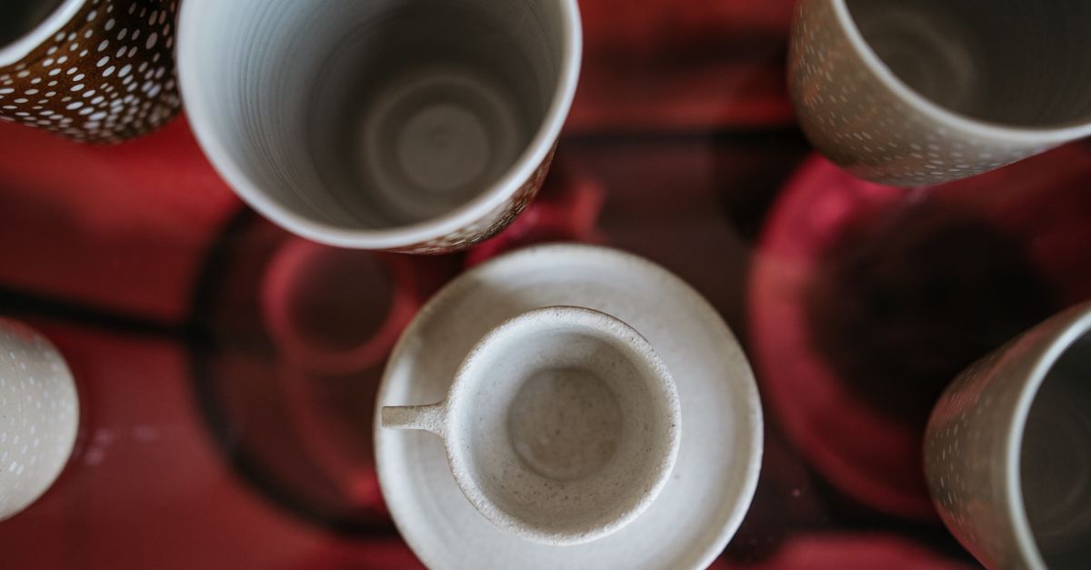 Tazas de cerámica clara apoyadas sobre una superficie neutra con luz natural suave